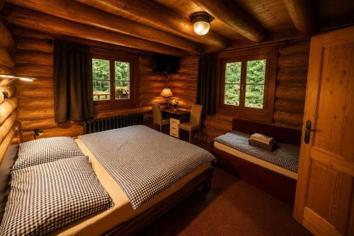 a bedroom with two beds in a log cabin at Pohádkový Srub Salaš in Salaš