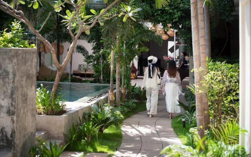 two women walking down a walkway in a garden at Serenity Boutique in Siem Reap
