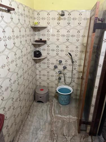 a bathroom with a shower and a bucket in it at Gem Backpackers Hostel in Siliguri