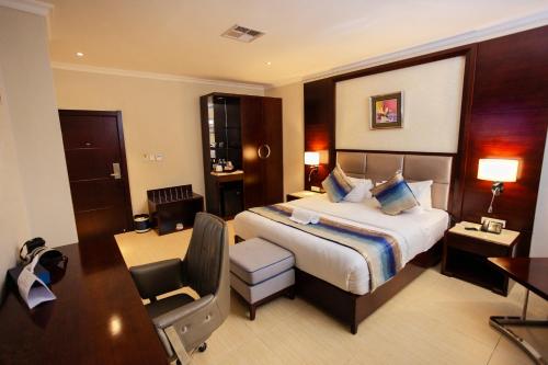 a bedroom with a bed and a desk and a chair at Grand Palace Hotel Lusaka in Lusaka