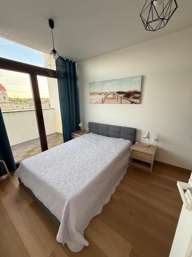 a bedroom with a bed and a large window at Grunwaldzka 62 in Bydgoszcz