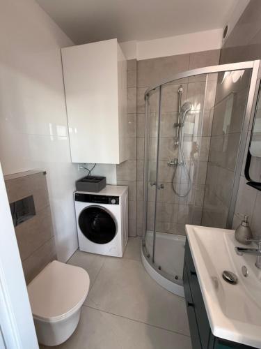 a bathroom with a shower and a washing machine at Grunwaldzka 62 in Bydgoszcz