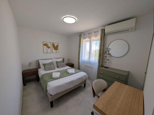 a bedroom with a bed and a table and a desk at Le Jasmin in Mauguio