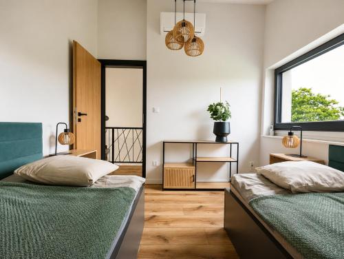 a bedroom with two beds and a window at Skośne Domki in Chmielno