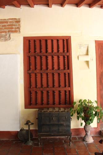 a wall with a wooden door and a plant next to it at CASA SINNING-año1637 in Mompos