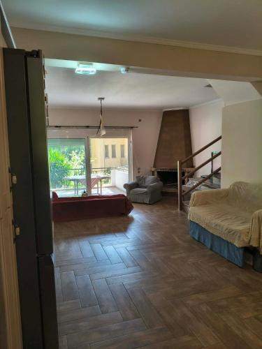 a room with a bed and a living room at Agios Stefanos TwoStory Maisonette in Néa Zoryiáni