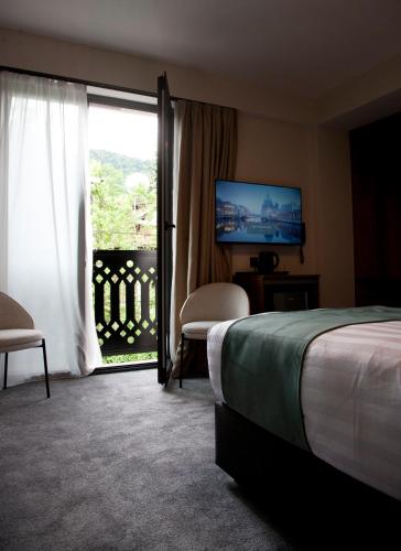 a hotel room with a bed and a large window at Borjomind Hotel Borjomi in Borjomi