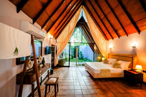 a bedroom with a bed and a large window at Taro River Resort Negombo in Otarawadiya