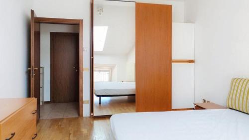 a bedroom with a bed and a door leading into a room at Levico Old Town Loft in Levico Terme