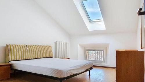 a bedroom with a bed with a skylight and a window at Levico Old Town Loft in Levico Terme
