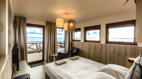 a bedroom with a bed and a view of the ocean at Pensjonat Kotwica in Kuźnica