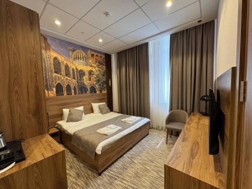 a hotel room with a bed and a tv at Imam Bukhari Grand Hotel in Khodzha-Ismail