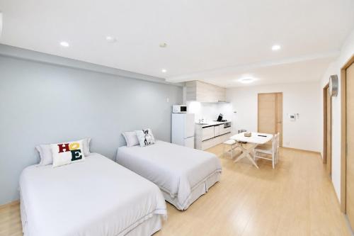a white room with two beds and a kitchen at Room 501 Japanese Tatami 3LDK 75sqm Near Namba Family Friendly Stay in Osaka