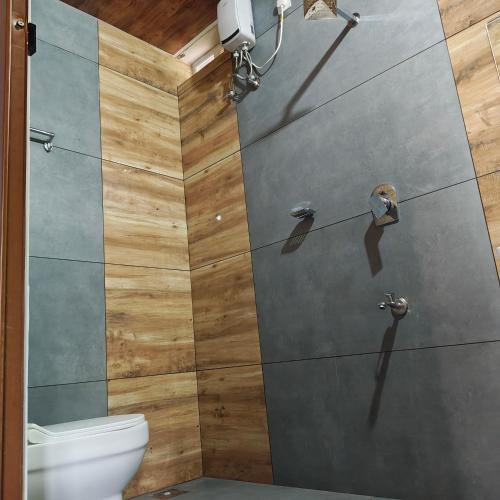 a shower stall in a bathroom with a toilet at The Royal Pool Resort-Swimming Pool Resort, Varkala in Varkala
