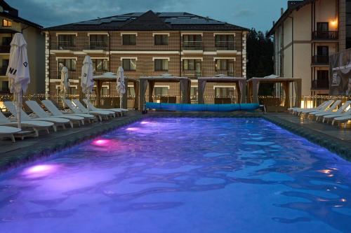 a large swimming pool with chairs and a hotel at Goral Hotel & Spa in Bukovel