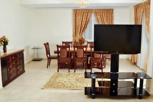 a living room with a large flat screen tv at Sara Hotel Apartments in Ajman 