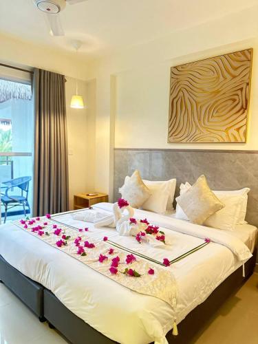 a bedroom with a large bed with flowers on it at YUVi Blue Guesthouse at Himmafushi in Himmafushi