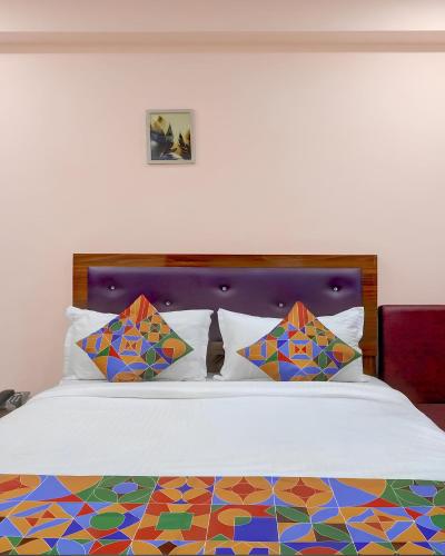 a bedroom with a bed with a colorful comforter and pillows at Embassy Gate Residency - opp US Embassy in Chennai