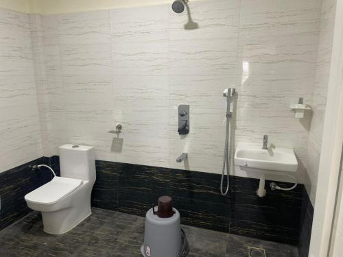 a bathroom with a toilet and a sink at SSR PARADISE ROOMs in Kavarapettai