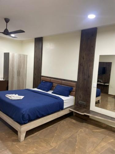 a bedroom with a bed with blue sheets and blue pillows at SSR PARADISE ROOMs in Kavarapettai