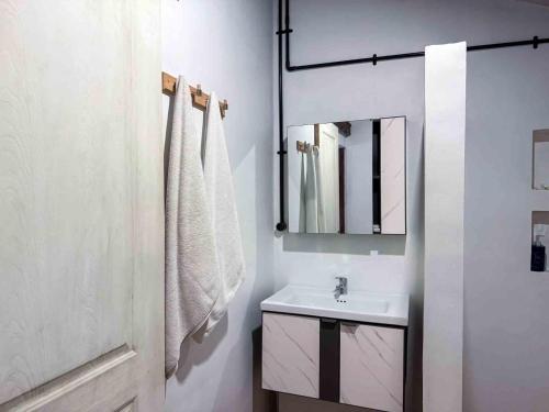a white bathroom with a sink and a mirror at Nalendro Villa Borobudur in Borobudur