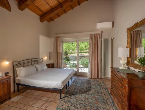 a bedroom with a bed and a large window at Eremo della Gasprina in La Morra