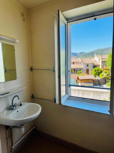 a bathroom with a sink and a window with a view at Oustal de Bourdeaux in Bourdeaux