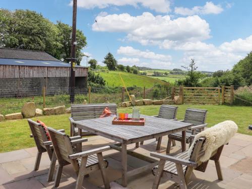 a wooden table and chairs on a patio at Pantglas in Llandysul