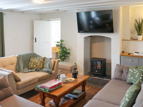 a living room with two couches and a table at Pantglas in Llandysul