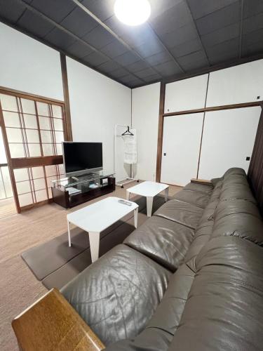 a living room with a couch and a tv at 民泊びんご1 in Onomichi