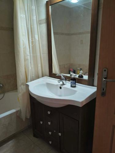 a bathroom with a sink and a mirror at Agios Stefanos TwoStory Maisonette in Néa Zoryiáni