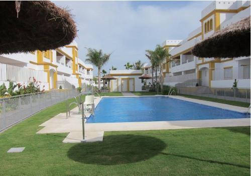 a swimming pool in front of a building at Apartamento Playa de Punta Candor in Rota