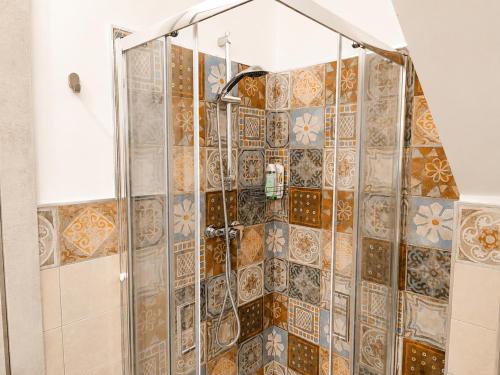 a shower in a bathroom with tiles on the wall at B&B Interno SG in LʼAquila