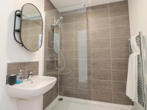 a bathroom with a shower and a sink and a mirror at Apartment 20, River View in Preston