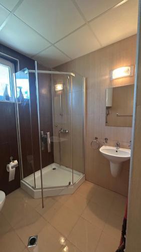 a bathroom with a shower and a sink at Корал in Obzor