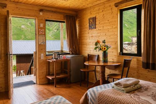 a room with a bed and a table in a cabin at Ushguli Cabins l Cafe in Ushguli