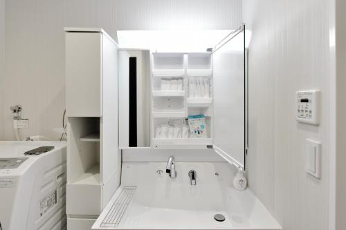 a small white kitchen with a sink and a sink at Room 701 Large 3LDK 98sqm Near Namba Big Balcony Ideal for Groups and Long Stay in Osaka