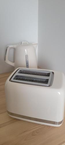 a white toaster sitting on a wooden table at Natura2000 in Châteauroux