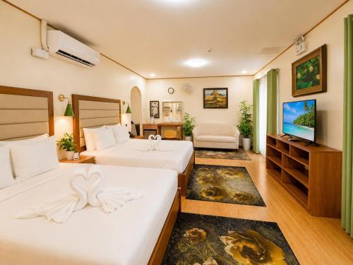 a hotel room with two beds and a flat screen tv at Sky Garden Homestay in Olongapo