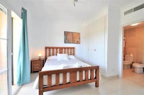 a bedroom with a wooden bed and a bathroom at Villa Mares Puig in Llucmajor