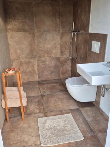 a bathroom with a white sink and a toilet at Lake window in Škofja Vas