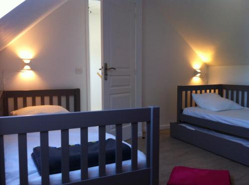 a bedroom with two beds and two lights on the wall at chateaugite in Pontlevoy