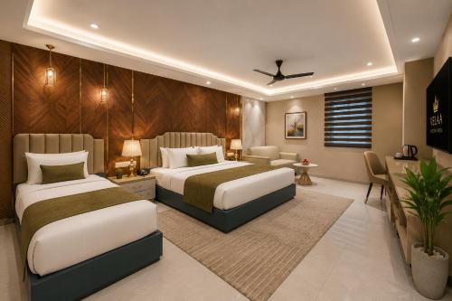 a hotel room with two beds and a couch at Hotel Luxury Stay Igi Airport Delhi in New Delhi