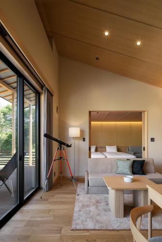 a living room with a bed and a telescope at Nemu Resort Hotel Nemu in Shima