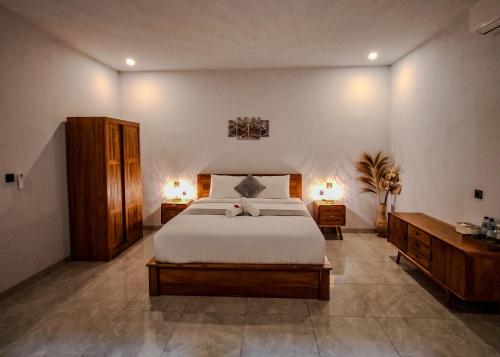 a bedroom with a large bed and two night stands at Devarastra Villa #3 in Amed