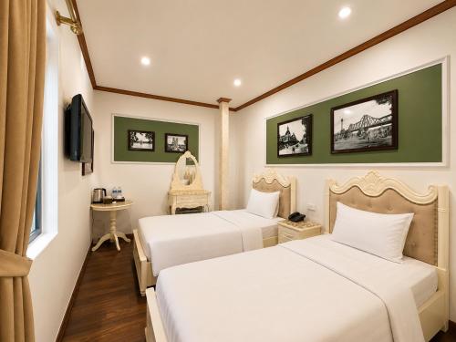 a hotel room with two beds and a television at Hanoi Silk Classy Hotel & Travel in Hanoi