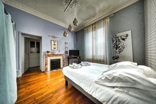 a bedroom with a white bed and a fireplace at La Source de la Scance in Verdun-sur-Meuse
