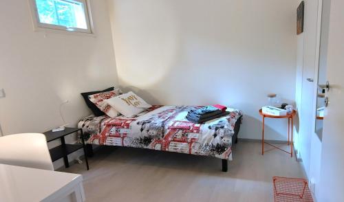 a small bedroom with a bed and a table at City & Forest Relax Room with Private Sauna & Garden in Espoo