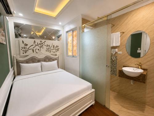 a bedroom with a white bed and a sink at Hanoi Silk Classy Hotel & Travel in Hanoi