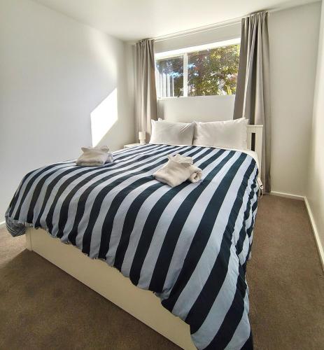 a bedroom with a black and white striped bed at Dark Sky Retreat in Lake Tekapo